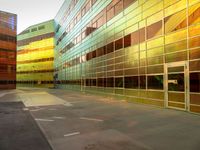 three colorful buildings reflecting each other in a large courtyard, and a bicycle lane underpass