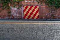 the door to an old building is red and yellow with a striped stripe pattern on it