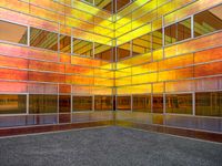 colorful photograph of a large glass building surrounded by parking lot and windows with no glass