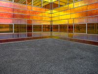 colorful photograph of a large glass building surrounded by parking lot and windows with no glass