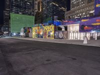 a colorful graffiti covered building with a big moon at night and some buildings all around it