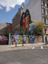 a colorful graffiti is on the side of a building in an intersection with cars and a van