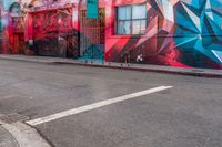 a fire hydrant on the side of a road with red graffiti painted all over it