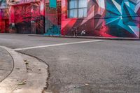 a fire hydrant on the side of a road with red graffiti painted all over it