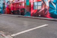 a fire hydrant on the side of a road with red graffiti painted all over it