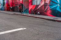 a fire hydrant on the side of a road with red graffiti painted all over it