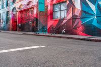 a fire hydrant on the side of a road with red graffiti painted all over it