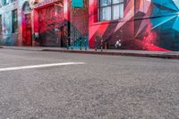 a fire hydrant on the side of a road with red graffiti painted all over it