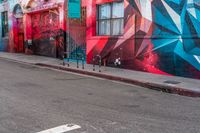 a fire hydrant on the side of a road with red graffiti painted all over it