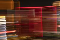 colorful light is seen from a moving bus on the street at night time in this photo