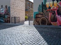 a colorful mural with animals, beer and barrels on a brick sidewalk in the town