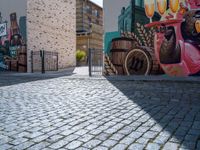 a colorful mural with animals, beer and barrels on a brick sidewalk in the town