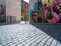 a colorful mural with animals, beer and barrels on a brick sidewalk in the town