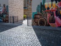 a colorful mural with animals, beer and barrels on a brick sidewalk in the town