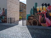 a colorful mural with animals, beer and barrels on a brick sidewalk in the town