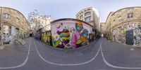 a spherical view of a street with a colorful painted building behind it in an alley