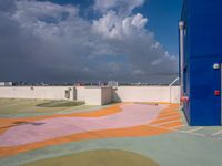 colorful pavement and colorful concretes with an open door at a parking lot with cloudy skies