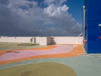 colorful pavement and colorful concretes with an open door at a parking lot with cloudy skies