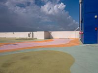 colorful pavement and colorful concretes with an open door at a parking lot with cloudy skies