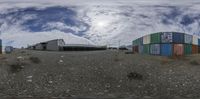 three colorful shipping containers in front of a sky with white clouds overhead as they are parked