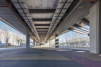 the underside of an overpass shows many areas with colorful tiles and lines of paint