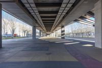 the underside of an overpass shows many areas with colorful tiles and lines of paint