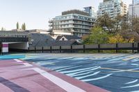 colorful parking space in front of tall buildings and apartment complex in urban area area with skateboarder