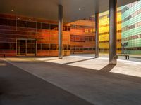 the large windows look very colorful from every angle outside the building and inside the building is concrete