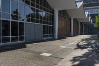 the entrance of a modern commercial building with windows and a bench in front of it