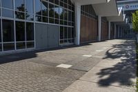 the entrance of a modern commercial building with windows and a bench in front of it