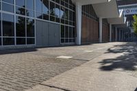 the entrance of a modern commercial building with windows and a bench in front of it