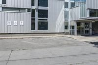 an empty street corner and a parking lot in front of a large building with lots of windows