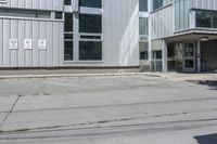 an empty street corner and a parking lot in front of a large building with lots of windows