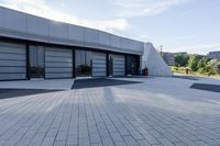 a view of an outside area of an office building with large windows and a circular driveway