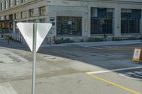 a crosswalk in a commercial city area, with an umbrella sign on it's pole