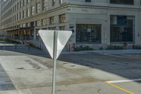 a crosswalk in a commercial city area, with an umbrella sign on it's pole