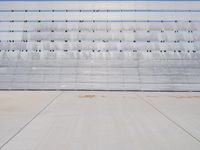 the concrete and seats are lined with lines and dots on the wall of the bleachers