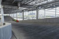 a skate boarder is riding down the edge of an empty ramp in a building