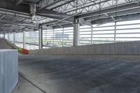 a skate boarder is riding down the edge of an empty ramp in a building