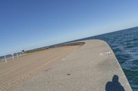 a beach covered in concrete with a sky background and water surrounding it with two blue sky