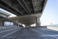 Concrete Bridge on Asphalt Road Under Clear Sky