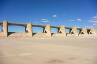 a concrete bridge in the middle of nowhere, under a cloudless blue sky at the bottom