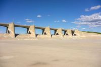 a concrete bridge in the middle of nowhere, under a cloudless blue sky at the bottom