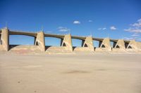 a concrete bridge in the middle of nowhere, under a cloudless blue sky at the bottom