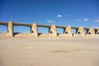 a concrete bridge in the middle of nowhere, under a cloudless blue sky at the bottom