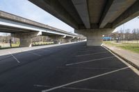 two overpasses over the roadway on an empty road between two other bridges near a park