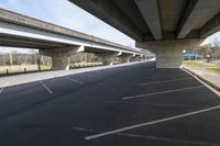 two overpasses over the roadway on an empty road between two other bridges near a park