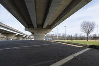 a large concrete bridge over a road with two lanes in the middle of it to the right