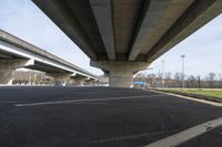 a large concrete bridge over a road with two lanes in the middle of it to the right