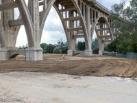 a construction site with many different levels of bridge under construction and a man walking toward the left